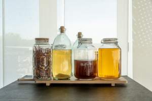 Bonbonnes en verre de sirops, vinaigres et alcools infusés maison au restaurant Le Saltimbanque en Baie de Somme.