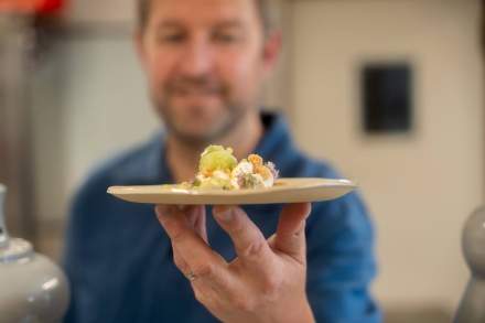 Chef présentant une assiette au restaurant gastronomique Le Saltimbanque en Baie de Somme