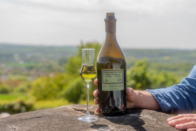 Bouteille de Chartreuse V.E.P. et verre à dégustation face au panorama du restaurant Le Saltimbanque à Eaucourt-sur-Somme.
