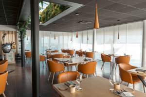 Salle contemporaine aux larges baies vitrées et mobilier design du restaurant gastronomique Le Saltimbanque en Baie de Somme.