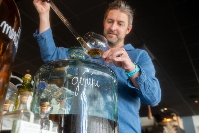 Le chef Sébastien Porquet servant une liqueur artisanale à la pipette depuis une bonbonne de génépi au restaurant Le Saltimbanque à Eaucourt-sur-Somme.